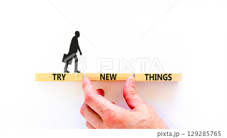 Try new things symbol. Concept words Try new things on beautiful wooden block. Businessman's hand. Beautiful white background. Business motivational lifestyle try new things concept. Copy space. Try new things symbol. Concept words Try new things on beautiful wooden block. Businessman's hand. Beautiful white background. Business motivational lifestyle try new things concept. Copy space. 129285765