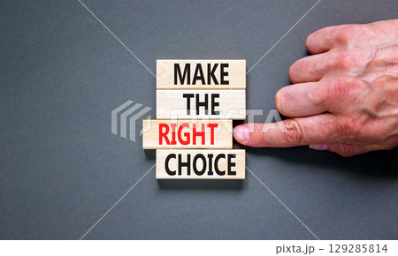 Make the right choice symbol. Concept words phrase Make the right choice on beautiful wooden blocks. Beautiful grey background. Businessman's hand. Business Make the right choice concept. Copy space. 129285814