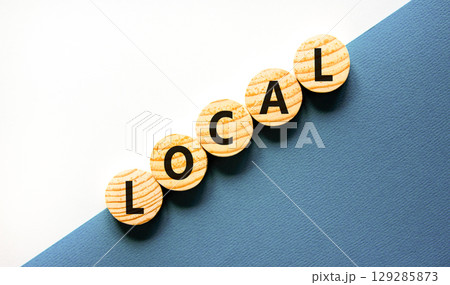 Local symbol. Concept word Local on beautiful wooden circles. Beautiful white and blue background. Business lifestyle local concept. Copy space. Local symbol. Concept word Local on beautiful wooden circles. Beautiful white and blue background. Business lifestyle local concept. Copy space. 129285873