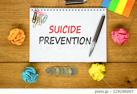 Suicide prevention symbol. Concept words Suicide prevention on beautiful white note. Beautiful wooden table wooden background. Black pen. Psychological suicide prevention concept. Copy space. 129286007