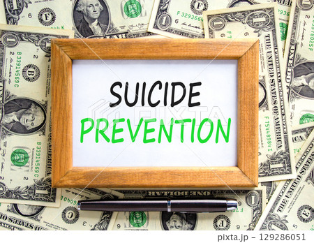 Suicide prevention symbol. Concept words Suicide prevention on beautiful wooden picture frame. Dollar bills. Beautiful background from dollar bills. Psychological suicide prevention concept Copy space Suicide prevention symbol. Concept words Suicide prevention on beautiful wooden picture frame. Dollar bills. Beautiful background from dollar bills. Psychological suicide prevention concept Copy space 129286051