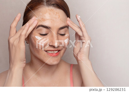 Woman uses a cream to combat pigmentation. Cream with protection against ultraviolet rays SPF. face with pigmentation, melasma, freckles, age spots photo Woman uses a cream to combat pigmentation. Cream with protection against ultraviolet rays SPF. face with pigmentation, melasma, freckles, age spots photo 129286231