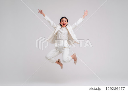 全身で喜びを表現する女性|白背景でジャンプするビジネスウーマンの笑顔 全身で喜びを表現する女性|白背景でジャンプするビジネスウーマンの笑顔 129286477
