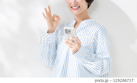 スマホを持つ女性 129286717