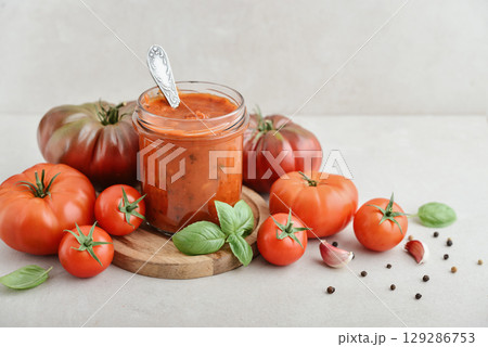 Traditional tomato sauce in a glass jar with fresh basil 129286753
