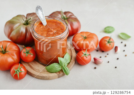 Traditional tomato sauce in a glass jar with fresh basil 129286754
