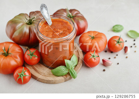 Traditional tomato sauce in a glass jar with fresh basil 129286755