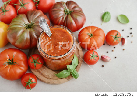Traditional tomato sauce in a glass jar with fresh basil 129286756