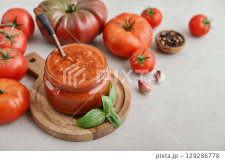 Traditional tomato sauce in a glass jar with fresh basil Traditional tomato sauce in a glass jar with fresh basil 129286778