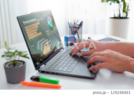 Man using 2 in 1 laptop to financial data analysis 129286881