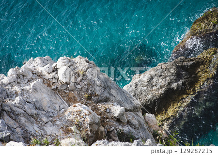 Stunning view of Calella de Palafrugell's pristine coastline featuring traditional whitewashed Mediterranean architecture, crystal-clear turquoise waters, and dramatic rocky outcrops along Costa Brava 129287215