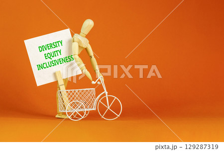 DEI diversity equity inclusiveness symbol. Concept words Diversity Equity Inclusiveness on white card. Beautiful orange background. Business DEI diversity equity inclusiveness concept. Copy space. DEI diversity equity inclusiveness symbol. Concept words Diversity Equity Inclusiveness on white card. Beautiful orange background. Business DEI diversity equity inclusiveness concept. Copy space. 129287319