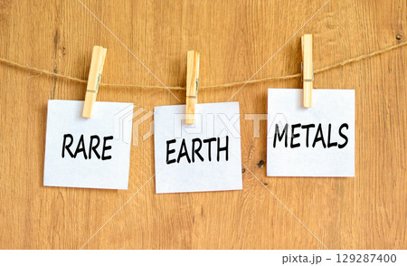 Rare earth metals symbol. Concept words Rare earth metals on beautiful white paper on wooden clothespin. Beautiful wooden background. Business and rare earth metals concept. Copy space. 129287400