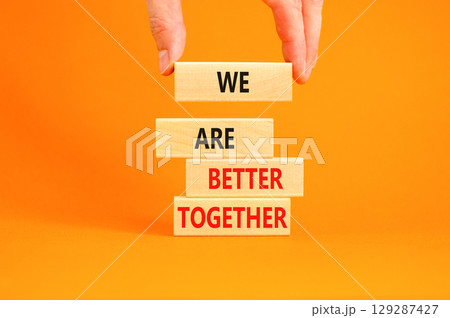 We are better together symbol. Concept words phrase We are better together on beautiful wooden blocks. Beautiful orange background. Businessman hand. Business We are better together concept Copy space 129287427