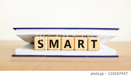 Smart symbol. Concept word Smart on beautiful wooden blocks in book. Beautiful wooden table white background. Business lifestyle smart concept. Copy space. 129287457