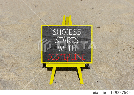Success starts with discipline symbol. Concept words Success starts with discipline on beautiful blackboard. Beautiful sand background. Business success starts with discipline concept. Copy space 129287609