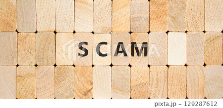 Scam symbol. Concept word Scam on beautiful wooden blocks. Beautiful wooden blocks background. Business, lifestyle, support and scam concept. Copy space. 129287612
