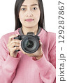 Woman Holding Black Mirrorless Camera Front View (Isolated) 129287867