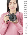 Woman Holding Black Mirrorless Camera Front View (Isolated) 129287871