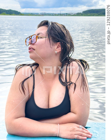 Girl in the water with a lake in the background Girl in the water with a lake in the background 129288076