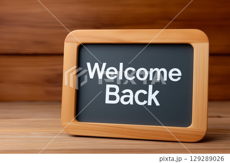 A small wooden-framed sign with "Welcome Back" in white text on a blackboard surface. 129289026