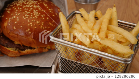 Serving a fast menu of beef burger and french fries in a special basket Serving a fast menu of beef burger and french fries in a special basket 129290290