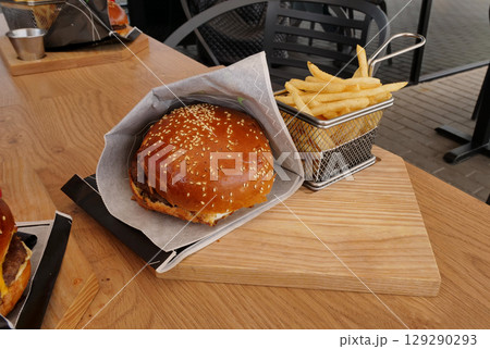 Classic serving of burger and fries on wooden board in a fast food restaurant 129290293