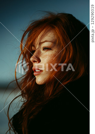A woman with red hair and a black jacket 129290319