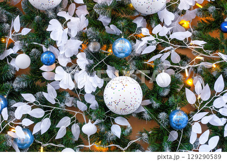 Christmas bauble with green fir branches, white leaves and illuminated 129290589