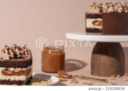 Chocolate sponge bento cake layered with caramel and nuts, topped with creamy frosting, presented on a wooden pedestal, showcasing a delightful dessert and pastry menu concept 129290636