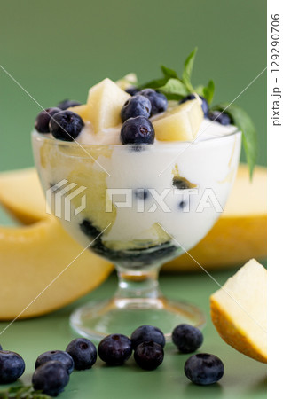 Creamy yogurt mousse with melon cubes and blueberries 129290706