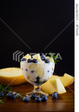 Dessert parfait of yogurt melon and blueberries on a wooden 129290709