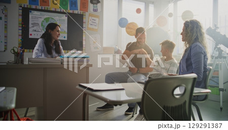 Mother and Father Looking at School Test Results of Their Son, Happy About Excellent Academic Performance Mother and Father Looking at School Test Results of Their Son, Happy About Excellent Academic Performance 129291387