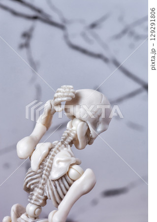 Skeleton figurine touching back of head. Headache migraine, neck pain, Cervical syndrome, traumatic concept Skeleton figurine touching back of head. Headache migraine, neck pain, Cervical syndrome, traumatic concept 129291806