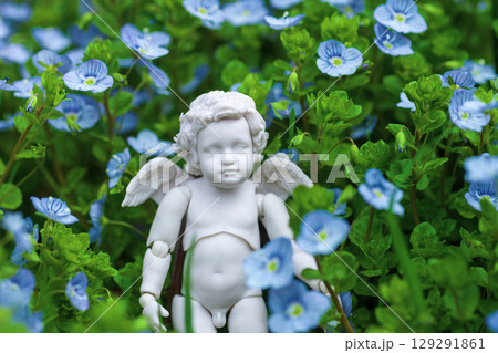 Angel baby figurine in Veronica peduncularis Georgia blue wild flowers. 129291861