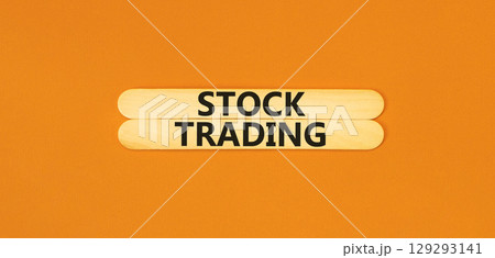 Stock trading symbol. Concept words Stock trading on beautiful wooden stick. Beautiful orange table orange background. Business stock trading concept. Copy space. Stock trading symbol. Concept words Stock trading on beautiful wooden stick. Beautiful orange table orange background. Business stock trading concept. Copy space. 129293141