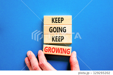 Keep going and growing symbol. Concept words phrase Keep going keep growing on beautiful wooden blocks. Beautiful blue background. Businessman's hand. Business Keep going growing concept. Copy space. Keep going and growing symbol. Concept words phrase Keep going keep growing on beautiful wooden blocks. Beautiful blue background. Businessman's hand. Business Keep going growing concept. Copy space. 129293202