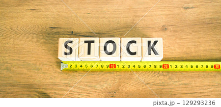 Stock symbol. Concept word Stock on beautiful wooden blocks. Beautiful wooden table wooden background. Beautiful yellow ruler. Business lifestyle stock concept. Copy space. 129293236