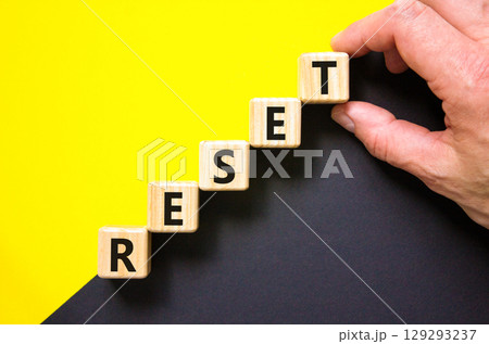 Reset symbol. Concept word Reset on beautiful wooden blocks. Beautiful yellow and black background. Businessman hand. Business lifestyle reset concept. Copy space. 129293237