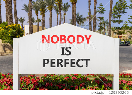 Nobody is perfect symbol. Concept words Nobody is perfect on beautiful white road sign. Beautiful palm tree hotel background. Business motivational lifestyle and nobody is perfect concept. Copy space. 129293266