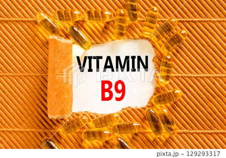 Vitamin B9 folic acid symbol. Concept words Vitamin B9 on beautiful white paper. Yellow pills tablets. Beautiful brown background. Medical healthy lifestyle Vitamin B9 concept. Vitamin B9 folic acid symbol. Concept words Vitamin B9 on beautiful white paper. Yellow pills tablets. Beautiful brown background. Medical healthy lifestyle Vitamin B9 concept. 129293317