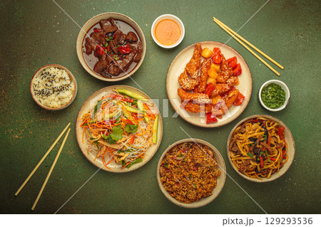 Variety of Chinese food dishes top view on table with chopsticks, rustic green background, cuisine of China Variety of Chinese food dishes top view on table with chopsticks, rustic green background, cuisine of China 129293536