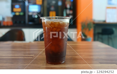 Iced Coffee in a Clear Plastic Cup on a Wooden Table 129294252