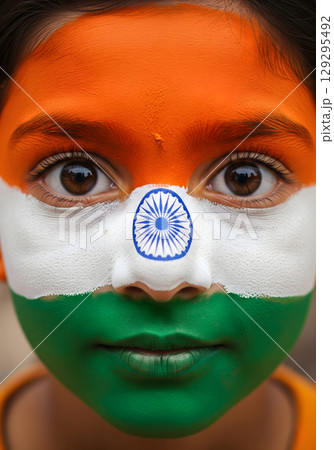 A young child with the flag of India painted on their face, looking at the camera with a neutral expression 129295492