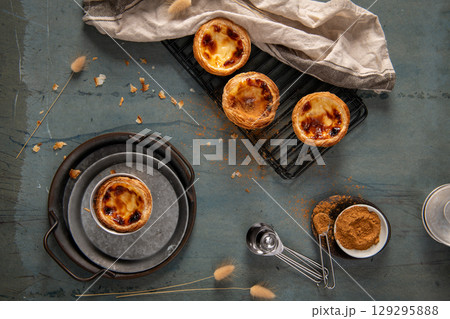Golden-brown Portuguese custard tarts, sprinkled with cinnamon 129295888