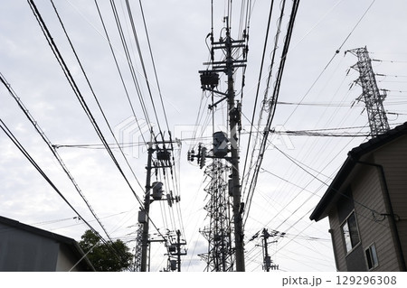 複雑に絡む電線と電柱、密集するインフラ設備 129296308