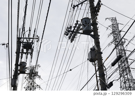 複雑に絡む電線と電柱、密集するインフラ設備 複雑に絡む電線と電柱、密集するインフラ設備 129296309