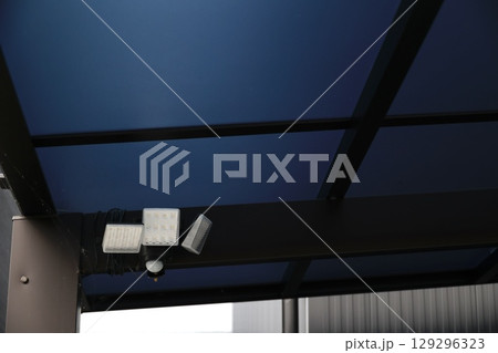 カーポートの屋根に取り付けられた防犯センサーライト 129296323