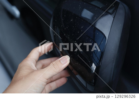 黒い車のサイドミラーに付着した白い汚れのクローズアップ写真。 129296326