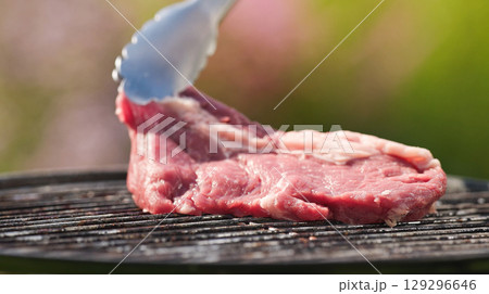 cook put fresh raw beef steak on charcoal grill cook put fresh raw beef steak on charcoal grill 129296646